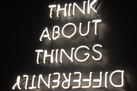 a neon sign that reads 'think about things differently'